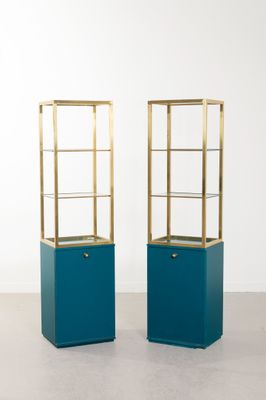 une paire de vitrines bleues et dorées dans une pièce blanche