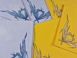 des serviettes jaunes et blanches ornées de fleurs bleues, posées sur une table