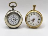 two clocks that are sitting next to each other on a table