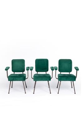 a set of four green velvet chairs with metal legs
