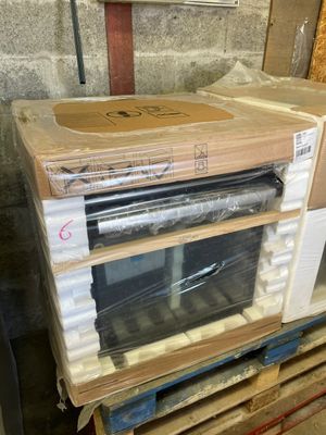a microwave sitting on top of a pallet in a warehouse
