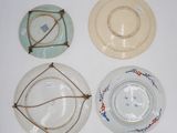 four plates with different designs on them on a white surface