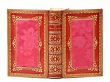 un livre rouge aux bords dorés et à la couverture rose