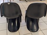 two black chairs sitting on a tiled floor in a room