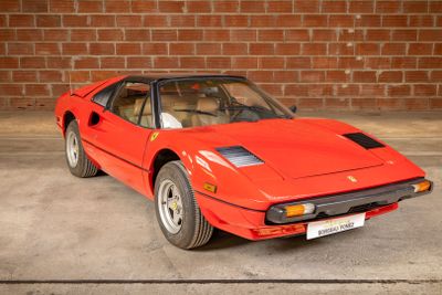 une voiture de sport rouge garée devant un mur de briques