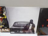 two cd ' s sitting on a shelf in front of a white wall