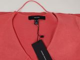a red sweater hanging on a hanger with a tag on it