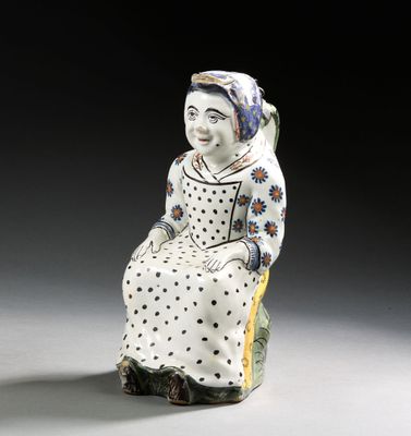 une figurine représentant une femme assise sur un rocher