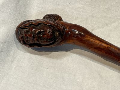 a wooden stick with a carved lion head on it