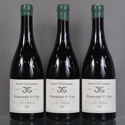 three bottles of wine are lined up on a table