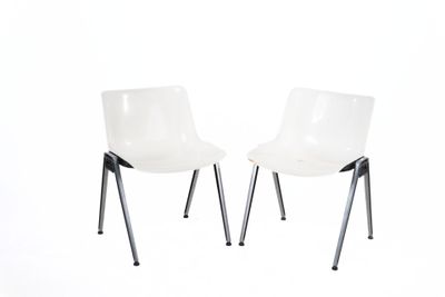 pair of white plastic chairs with metal legs against a white background