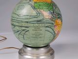 a green globe with a map on it on a metal stand