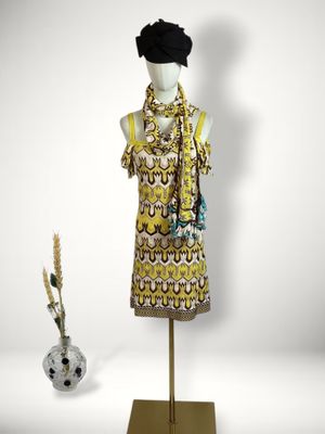 an image of a mannequin wearing a yellow dress and a black hat