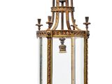 une lanterne ancienne en laiton et en verre posée sur une table en marbre