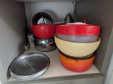 two bowls and pans sitting on a shelf in a kitchen