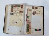 an open book with stamps on it sitting on top of a table