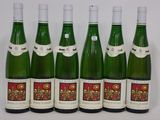 six bouteilles de vin sont alignées sur une table