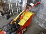 a red and yellow lawn mower parked in a garage