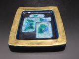 une assiette bleue et dorée sur laquelle figure une image