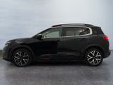 the black suv is parked in a large room with a sky background
