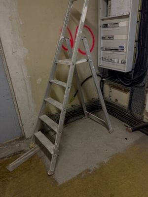 une échelle adossée au mur d'une pièce