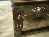 a wooden table with a carved top on a wooden floor