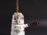 a tea pot with a wooden handle on a table