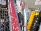 many rolls of fabric and rolls of wrapping in a storage area