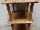 une petite table en bois sur laquelle se trouvent trois étagères