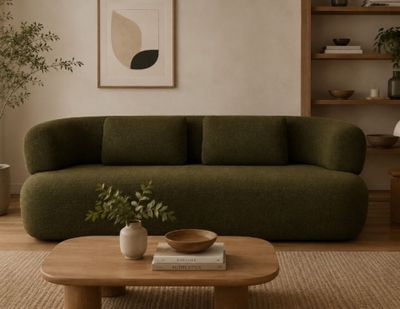 un salon avec un canapé vert et une table basse