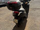 une moto garée sur un parking, avec un camion en arrière-plan