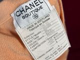 someone is holding a chanel sweater with a price tag on it