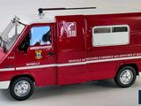 a red and white toy truck with a man in the window