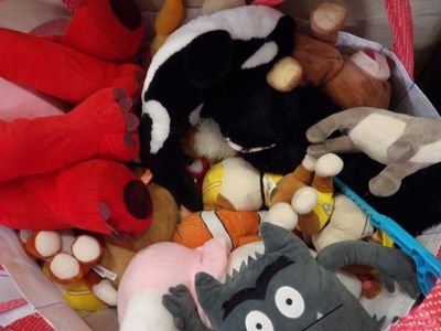 many stuffed animals in a basket together on the table