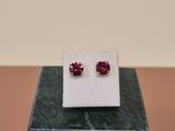 a pair of pink sapphire stud earrings sitting on top of a marble block