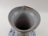 a blue and white vase sitting on a white surface