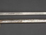 two old swords are displayed on a black surface