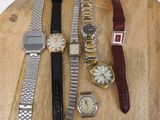 a lot of watches sitting on a wooden table