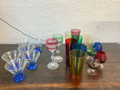 de nombreux verres de différentes couleurs posés sur une table en bois