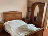 une chambre avec un lit, une commode et un miroir