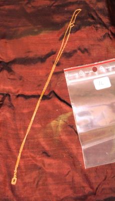 un sac en plastique auquel est attachée une chaîne, posé sur un lit
