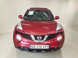 the front of a red nissan juke suv parked in a white room