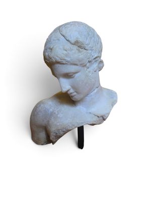 marble bust of a young boy on a stand on a white background