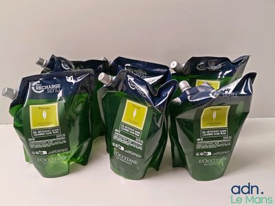 Quatre sachets de thé vert sont posés sur une table devant un fond blanc.