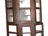 a wooden corner cabinet with glass doors on it