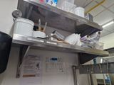 a metal shelf with pots and pans on top of it