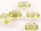 four green gems are arranged on a white surface