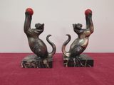 pair of cat bookends on marble base with red ball