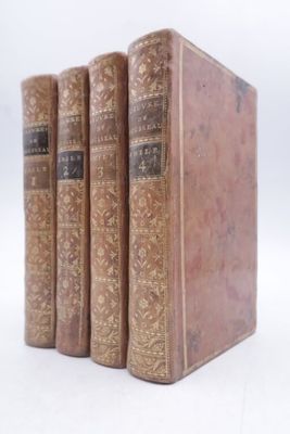 three old books sitting on top of each other on a white surface