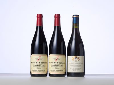 trois bouteilles de vin sont alignées sur une table